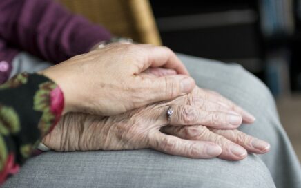 Photo of younger hands holding older hands courtesy Pixabay