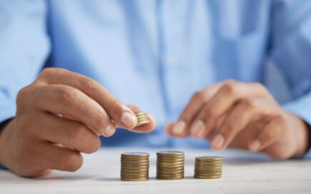 Photo of man putting coins into piles by Towfiqu barbhuiya on Unsplash