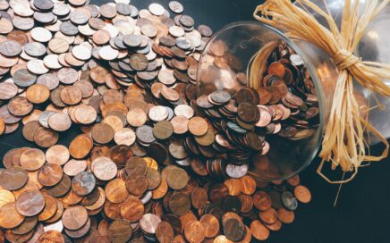 Image of a pile of pennies flowing out of a glass jar by Olya Adamovich from Pixabay