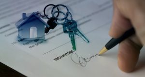 Photo of document being signed with a set of keys laying on the document courtesy Pixabay