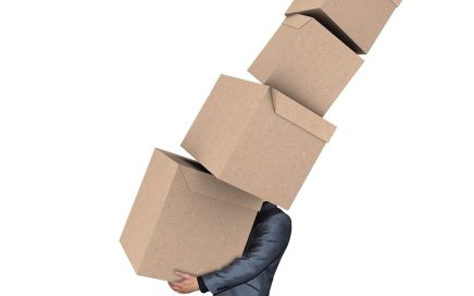 Illustration of a man holding a stack of boxes off-kilter courtesy Pixabay