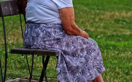 Two women sitting on a park bench talking