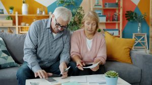 Photo of couple on couch looking at their finances by Vitaly Gariev on Unsplash